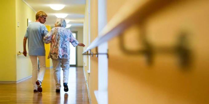 Eine Pflegerin begleitet eine Seniorin. Pflege