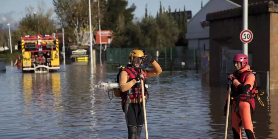 Rettungskräfte stehen auf dem Gelände eines Industrieparks. Foto: Daniel Cole/AP/dpa