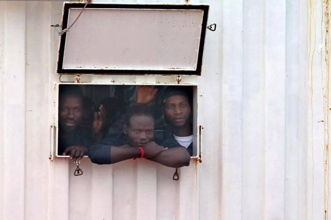 Migranten blicken Mitte Oktober aus der Öffnung eines Containers an Bord des Rettungsschiffes «Ocean Viking», das in den italienischen Hafen Tarent (Taranto) einläuft. Migranten
