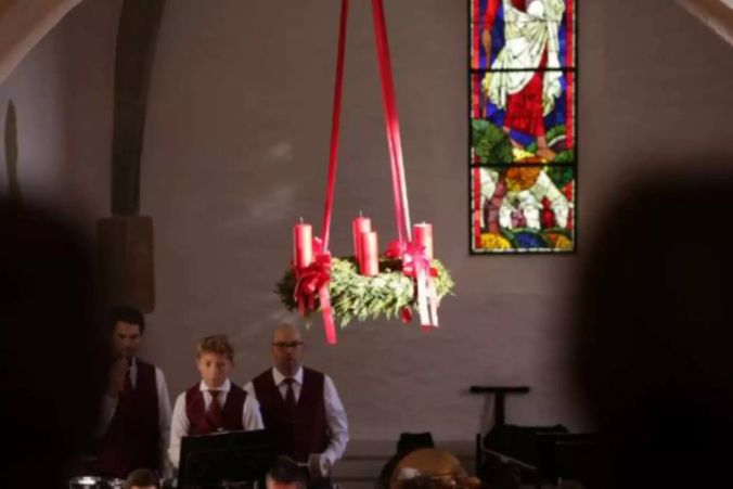 Ein wunderschöner Adventskranz schmückt Kirche und Konzert. Von wem mag er sein?