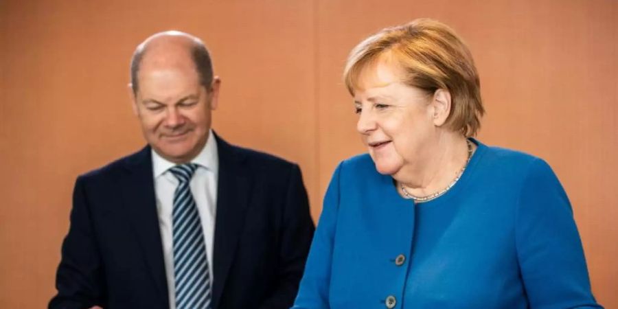 Bundesfinanzminister Scholz und Bundeskanzlerin Merkel vor Beginn einer der wöchentlichen Sitzungen des Bundeskabinetts. Foto: Michael Kappeler/dpa
