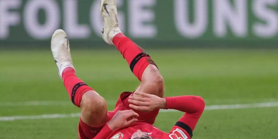 Leverkusens Havertz liegt am Boden und musste kurz vor der Halbzeit wegen einer Verletzung ausgewechselt werden. Foto: Peter Steffen/dpa