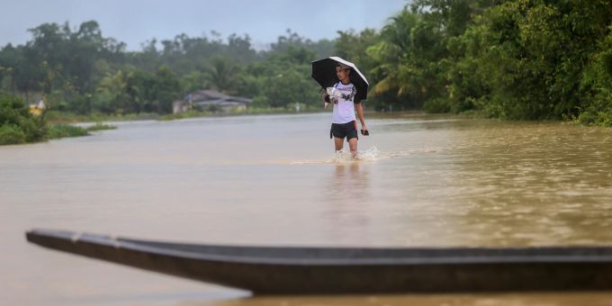 Ein Mann geht durch ein Überschwemmungsgebiet in Kuala Terengganu, Malaysia, 21. Dezember 2022. More than 70,000 evacuated in Malaysia floods