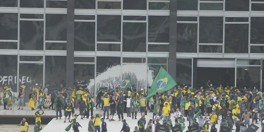 Anhänger des ehemaligen brasilianischen Präsidenten Bolsonaro stürmen den Palacio do Planalto, den offiziellen Sitz des brasilianischen Präsidenten. Foto: Eraldo Peres/AP/dpa