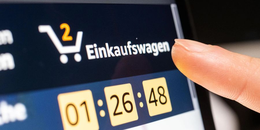 Ein Person klickt beim Online-Shoppen auf den Einkaufswagen.