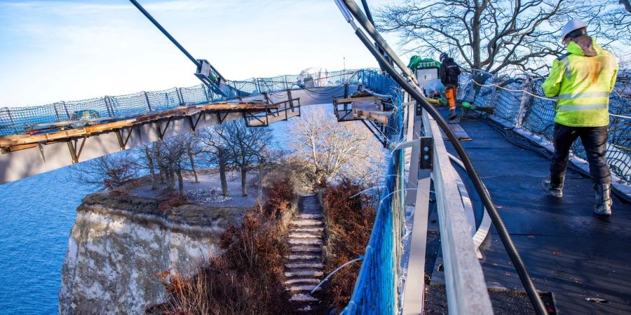 Auf der zukünftigen Besucherbrücke Königsweg wird die Absenkung des Rundwegs über dem Kreidefelsen «Königsstuhl» vorbereitet. Ab dem Frühjahr 2023 könnte die an einem Mast über dem 118 Meter hohen Königsstuhl schwebende Konstruktion für Besucher eröffnet werden.