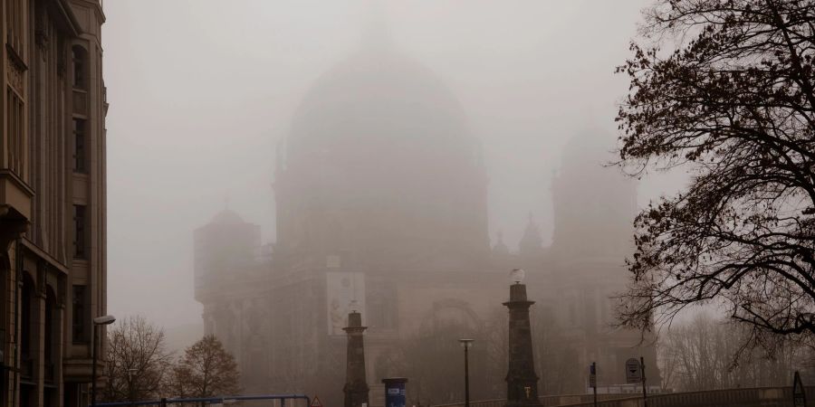 Nebelschwaden hängen tief über dem Dom in Berlin.