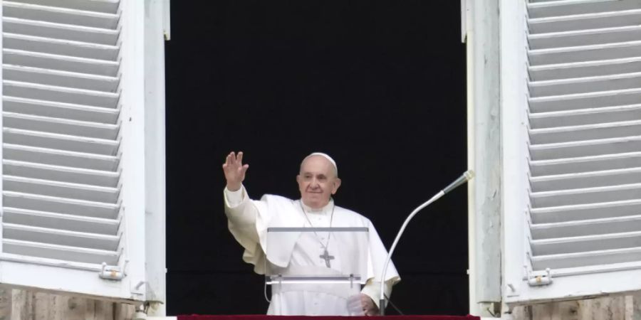 Papst Franziskus winkt aus seinem Fenster, während er das Angelus-Gebet auf dem Petersplatz spricht. Foto: Gregorio Borgia/AP/dpa