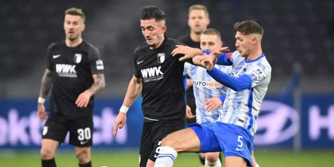 Herthas Niklas Stark (r) gegen Augsburgs Andi Zeqiri (M) kämpfen um den Ball. Foto: Soeren Stache/dpa-Zentralbild/dpa Herthas Niklas Stark (r) gegen Augsburgs Andi Zeqiri (M) kämpfen um den Ball. Foto: Soeren Stache/dpa-Zentralbild/dpa