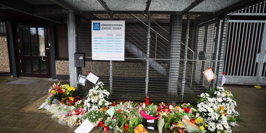 Blumen und Kerzen vor dem Eingangsbereich des Gemeindehauses in Hamburg, wo ein Amokläufer erst sieben Menschen und dann sich selbst erschossen hat.