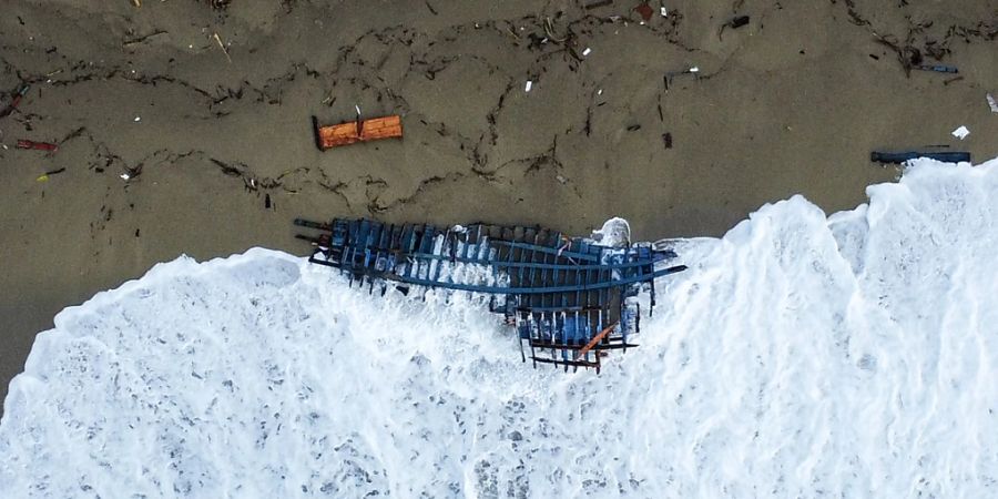 Blick auf einen Teil des Wracks eines gekenterten Bootes, das an einem Strand angeschwemmt wurde. Foto: Luigi Navarra/AP/dpa