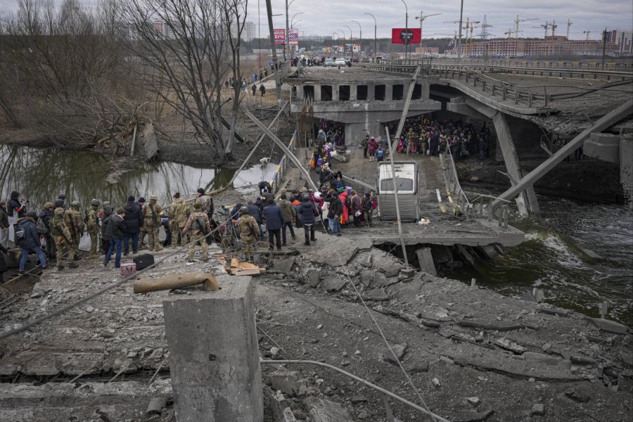 Eine von den Russen zerstörte Brücke bei Irpin wird am Samstag vom Militär als Fluchtweg für Zivilisten benutzt. Gemäss UN-Angaben sollen mehrere hundert Zivilisten im Konflikt bereits umgekommen sein.