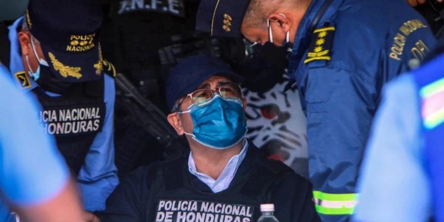 Juan Orlando Hernandez spricht mit Polizeibeamten nach seiner Festnahme in seinem Haus. Foto: Inti Ocon/dpa