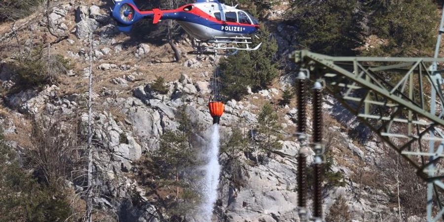 Ein Hubschrauber der österreichischen Polizei über den letzten Brandherden an der deutsch-österreichischen Grenze. Foto: Karl-Josef Hildenbrand/dpa