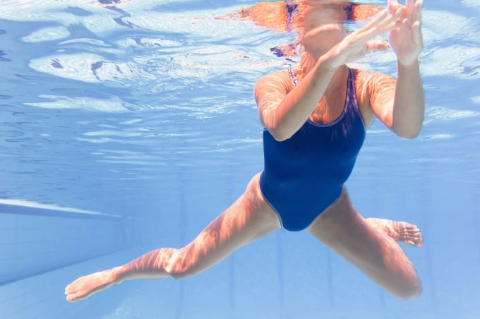 Der korrekte Einsatz von Armen und Beinen macht das Vorankommen im Wasser einfacher. Frau schwimmt