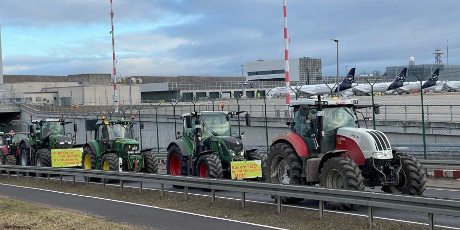 Traktoren fahren auf einer Strasse am Flughafen Frankfurt vorbei. Wie ein Polizeisprecher sagte, begaben sich die Bauern am Morgen gegen 6 Uhr Richtung Airport. Geplant sei eine Protestfahrt rund um das Gelände.