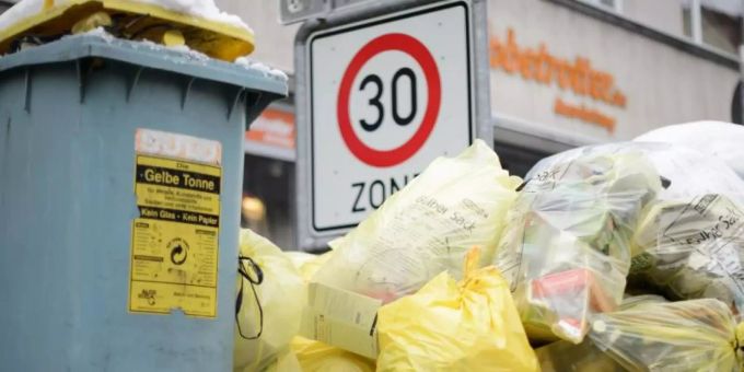 Mülltonnen und gelbe Säcke mit Kunststoff-Abfällen stapeln sich auf einem Fussweg. Foto: Sina Schuldt/dpa Mülltonnen und gelbe Säcke mit Kunststoff-Abfällen stapeln sich auf einem Fussweg. Foto: Sina Schuldt/dpa