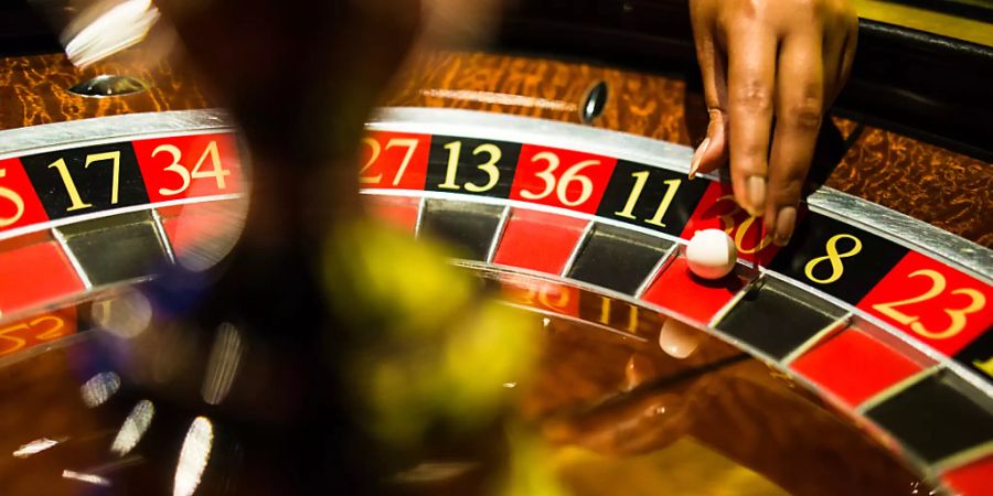 ARCHIV - Eine Mitarbeiterin der Spielbank Stuttgart greift beim Spiel Roulette nach einer Kugel, die auf Rot liegt. Foto: Christoph Schmidt/dpa