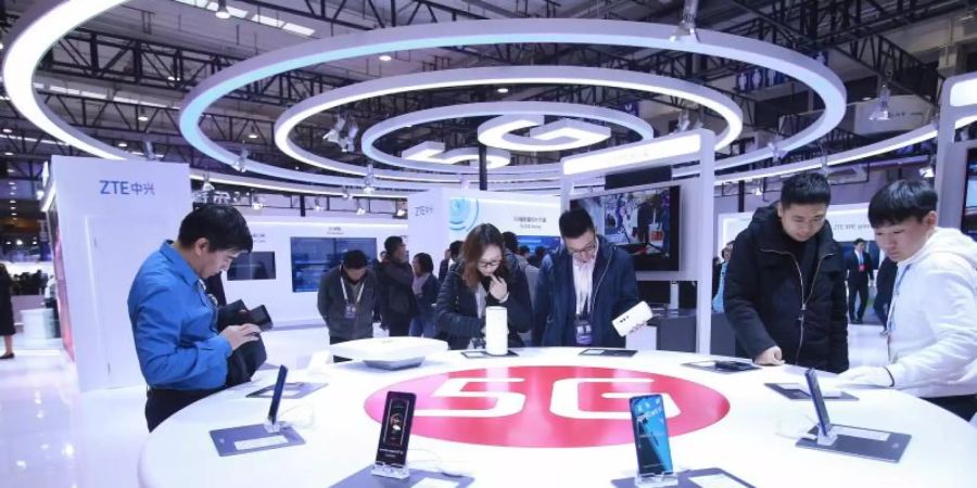 Besucher schauen neue Smartphones mit 5G-Technologie an. Foto: Chen Xiaogen/SIPA Asia via ZUMA Wire/dpa