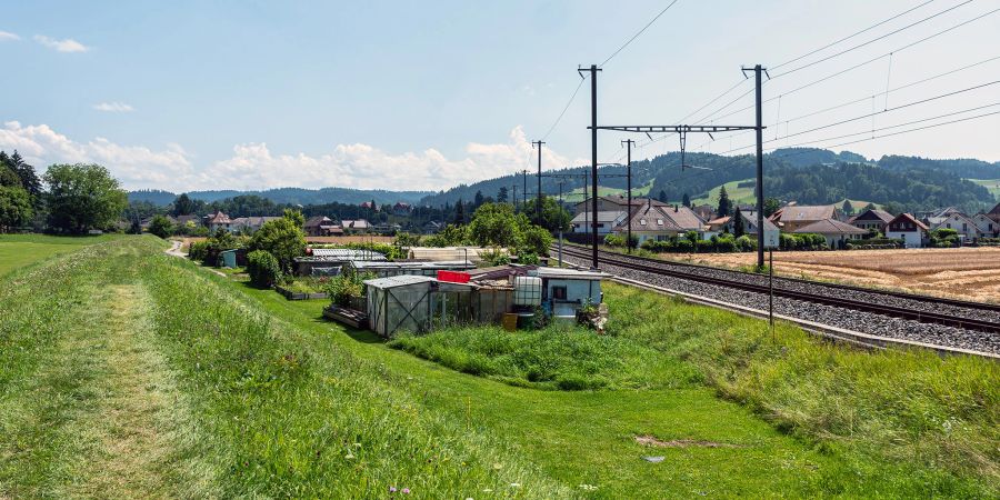 Die Landschaft bei Hasle bei Burgdorf mit Schrebergärten und der Eisenbahnlinie in Richtung Emmental. Hinten Hasle bei Burgdorf.