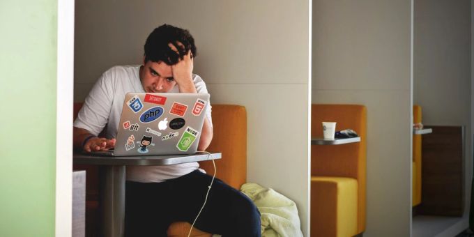 Wer nur das Nötigste im Job erledigt, sollte sich vielleicht nach einem anderen umsehen – bei dem auch die Begeisterung mit dabei ist. Mann Arbeit Tisch Laptop gestresst gelangweilt lustlos