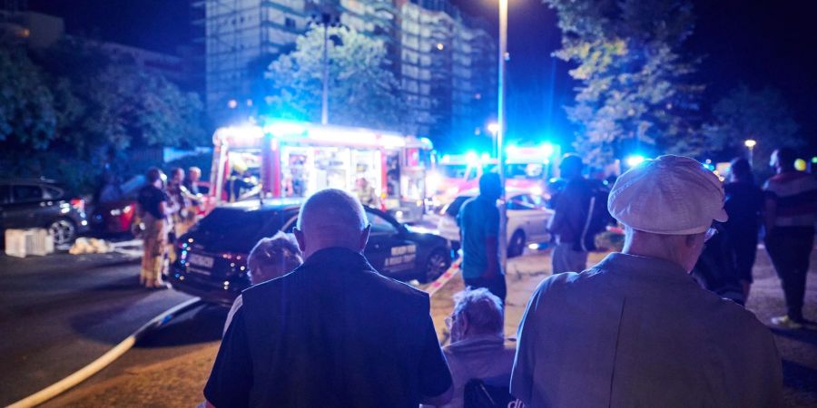 Evakuierte Bewohner des Mietshauses in Berlin, auf dessen Dach das Feuer ausgebrochen ist.