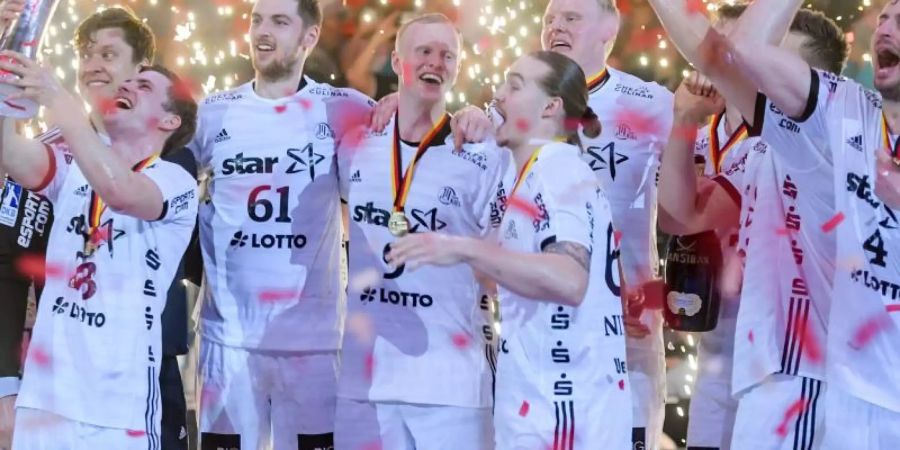 Nach der Feier die Terminhatz: Für vier Nationalspieler geht es sogleich zu einem Termin mit dem DHB-Team bei der Kanzlerin. Foto: Axel Heimken/dpa