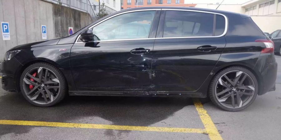 Schwarzes Auto mit leichter Beschädigung an der Seite