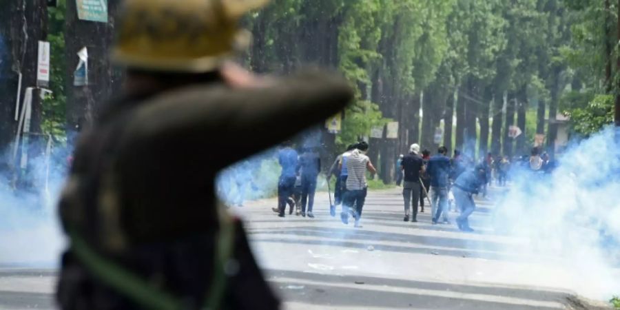 Polizei feuert Tränengas auf Demonstranten am Rand von Srinagar.