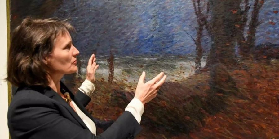 Kuratorin Uta Kuhl in der Ausstellung «Impressionist des Nordens - Hans Olde der Ältere» vor dem Bild «Hünengrab bei Bülk (Herbstturm am Meer)» aus dem Jahr 1894. Foto: Carsten Rehder