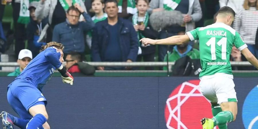 Werder-Stürmer Milot Rashica erzielt gegen Mainz-Torwart Florian Müller (l) das 1:0. Foto: Carmen Jaspersen/dpa