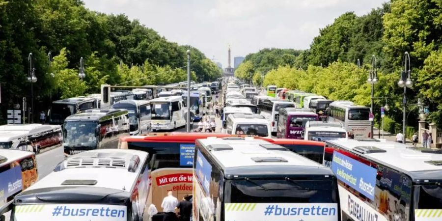 Reisebusse stehen bei einer Protestaktion zur wirtschaftlichen Lage von Bus- und Touristikunternehmen auf der Strasse des 17. Juni vor der Siegessäule in Berlin. Foto: Christoph Soeder/dpa