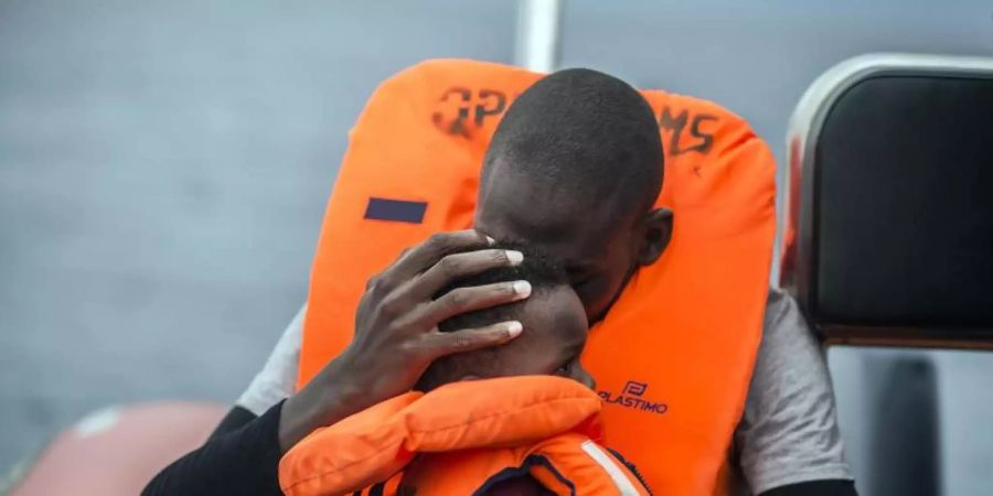 Ein Mann hält seinen Sohn im Arm, nachdem er gemeinsam mit anderen Flüchtlingen gerettet wurde. Foto: Javier Fergo/AP/dpa