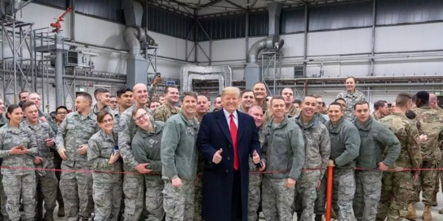 Donald Trump lässt sich 2018 während eines Zwischenstopps auf dem Stützpunkt der US-Luftwaffe in Ramstein mit Militärangehörigen fotografieren. Foto: Shealah Craighead/White House /dpa