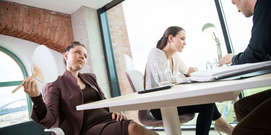 Ganz schön warm im Büro. Ab 30 Grad müssen Arbeitgeber tätig werden und Abhilfe schaffen.