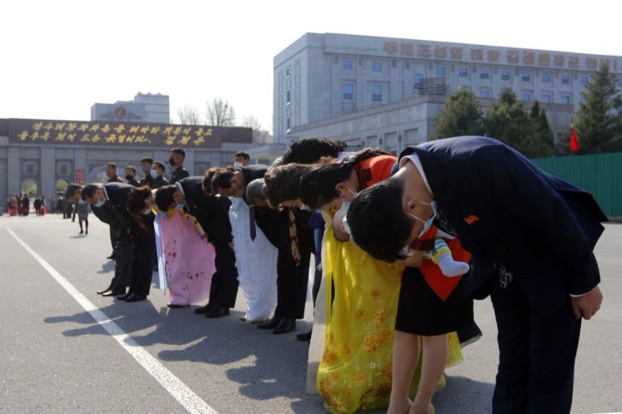 Menschen würdigen die Statue von Kim Il Sung und Kim Jong Il.