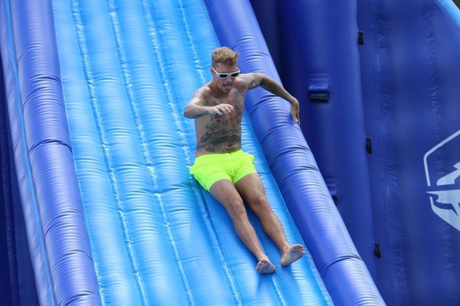 Justin Bieber rutscht auf einer Wasserrutsche in den See.