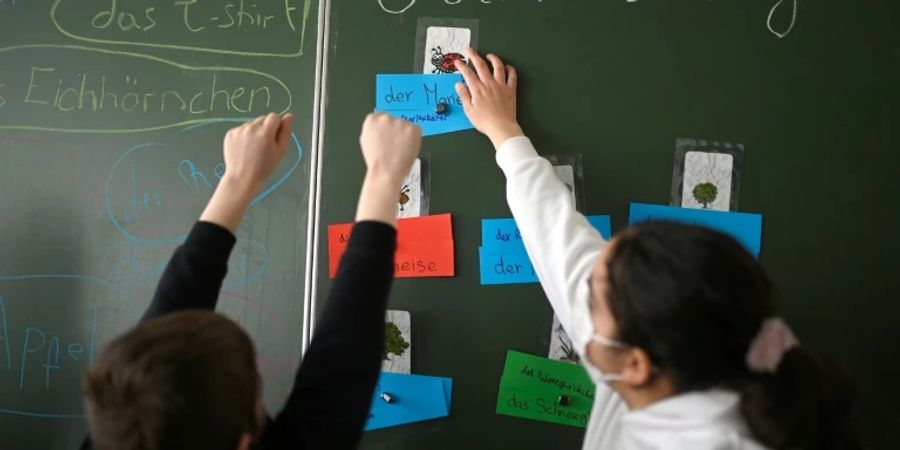 Geflüchteter Junge und Schülerin gemeinsam an der Tafel.