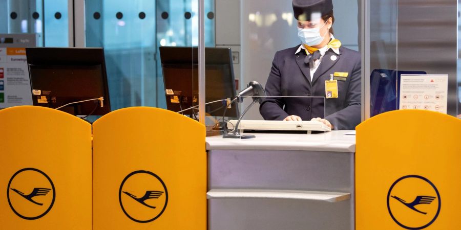 Eine Mitarbeiterin von Lufthansa bereitet an einem Gate am Flughafen München das Boarding für einen Flug vor.