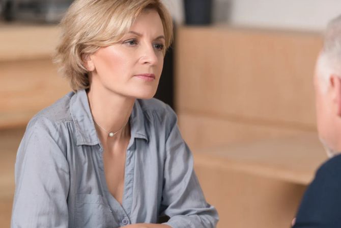 frau und mann reden miteinander, braune bank im hintergrund