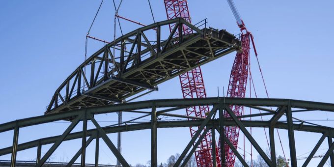 Der grösste Kran der Schweiz hebt ein 47 Meter langes Brückenelement in die Höhe. Kran hebt ein Brückenbauteil