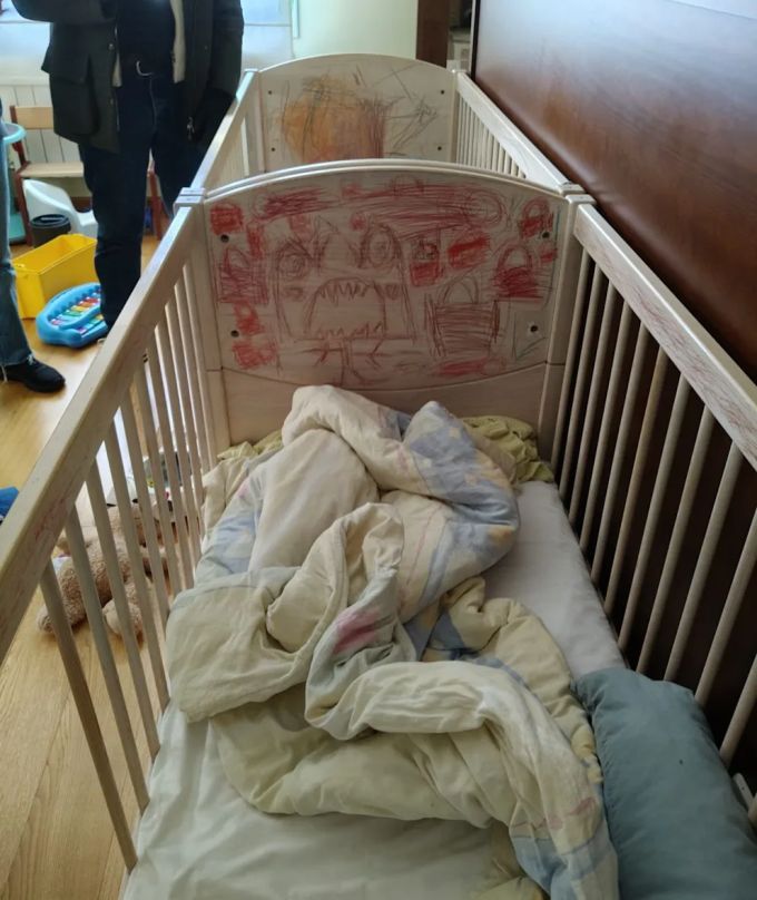 In diesen vergitterten Betten schliefen offenbar zwei der Kinder. Auf das Holz ist ein Monster gezeichnet. Polizei Spanien