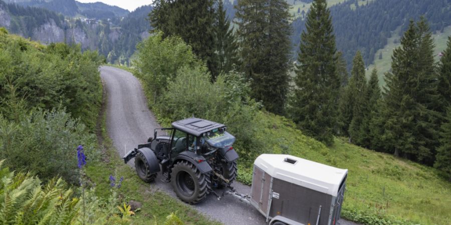 Ein Bewirtschafter transportiert mit seinem Traktor Wasser auf seine Alp. (Archivaufnahme)