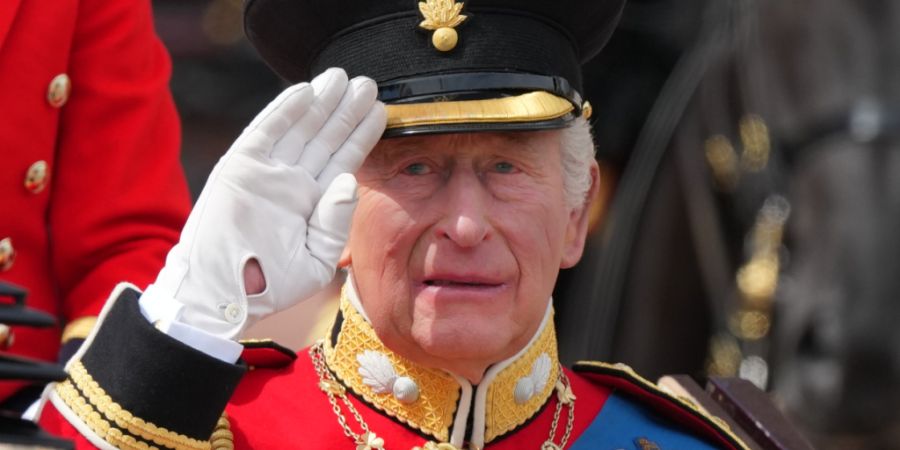 dpatopbilder - Der britische König Charles III. salutiert, während er gemeinsam mit Königin Camilla in einer offenen Kutsche bei der «Trooping the Colour», der jährlichen Geburtst...