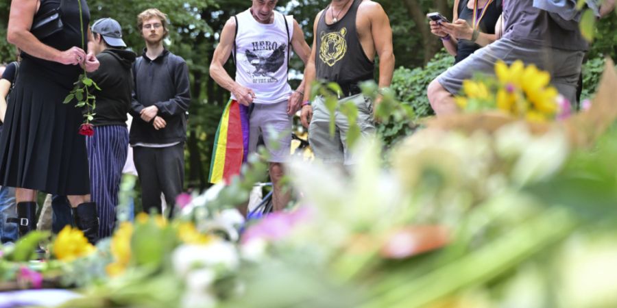 Menschen trauern in der Nähe des Tatorts. Am Rande des Christopher Street Day in Berlin war das Fahrzeug in eine Menschenmenge gefahren. Foto: Sebastian Gollnow/dpa - ACHTUNG: Nur zur ...