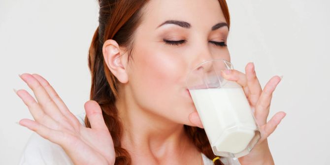 Glückliche Frau trinkt Milch