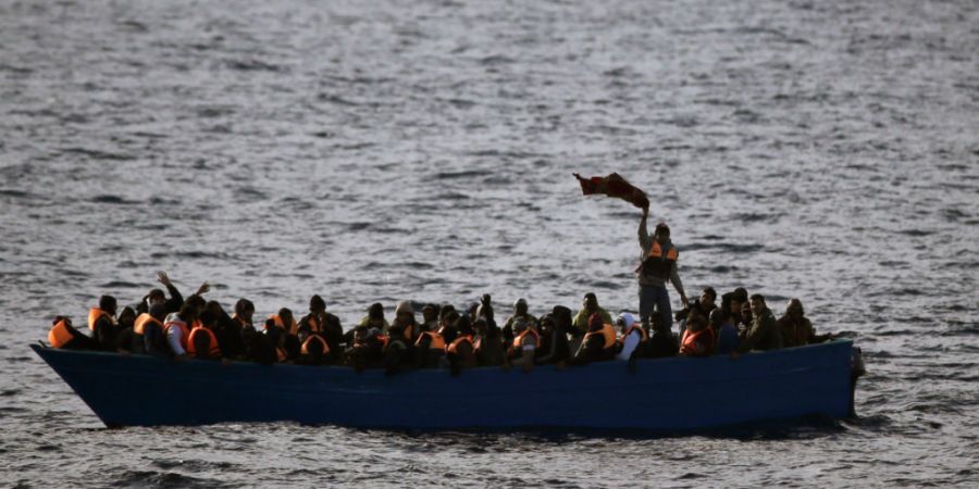 ARCHIV - Flüchtlinge aus Afrika rufen am 03.02.2017 auf dem Mittelmeer in einem Boot um Hilfe. (zu dpa: «Flüchtlingsboot vor Lampedusa gesunken: Kind vermisst») Foto: Emilio Morenat...