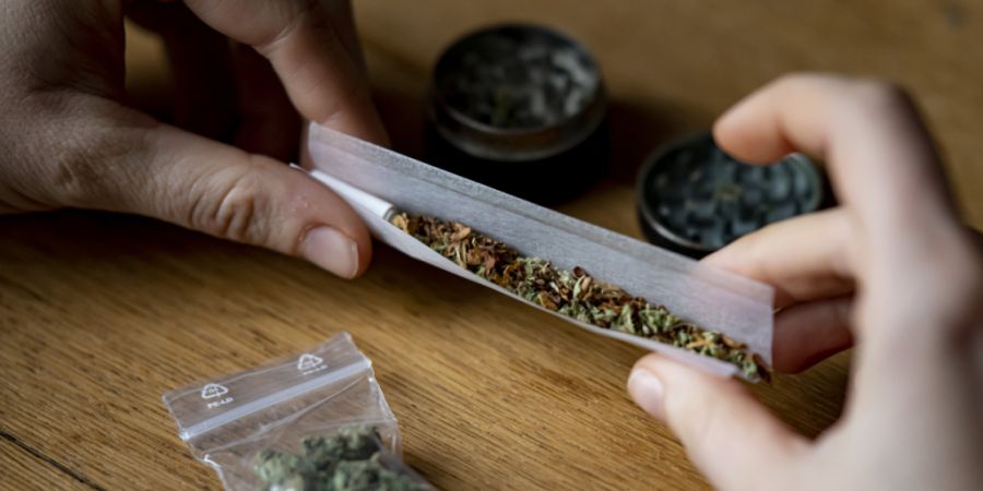 Eine Person dreht sich einen Joint. (Archivbild)