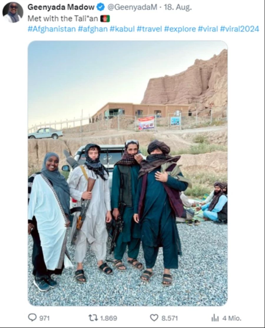 Die Reise-Bloggerin Geenyada Abdi posiert lächelnd neben Taliban-Kämpfern in Afghanistan.