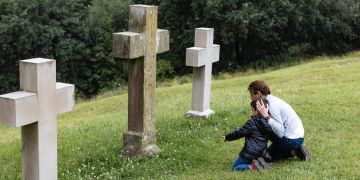 Mutte rund Sohn am Grabstein